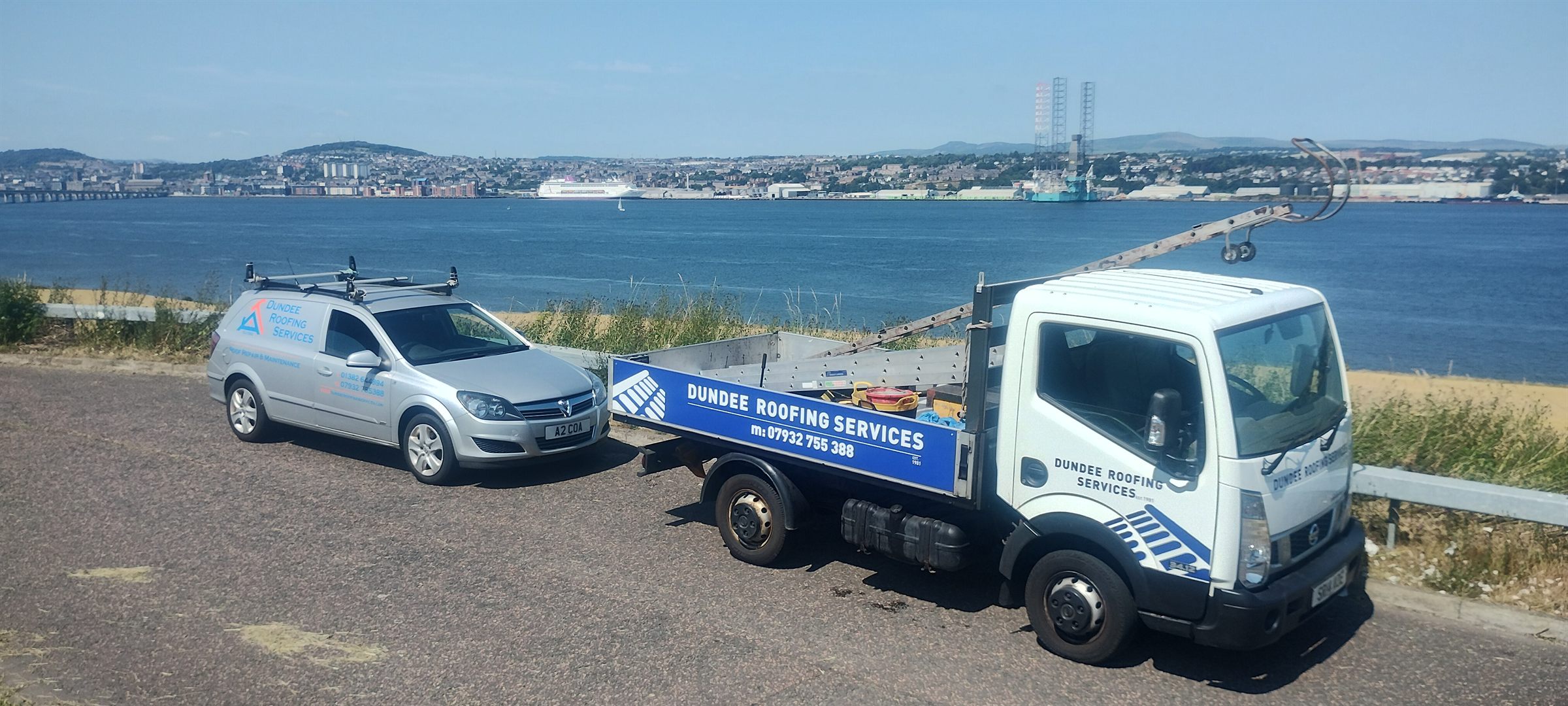 The Dundee Roofing Services tipper truck and van parked above the Tay, with the Tay Road Bridge and the Dundee waterfront behind