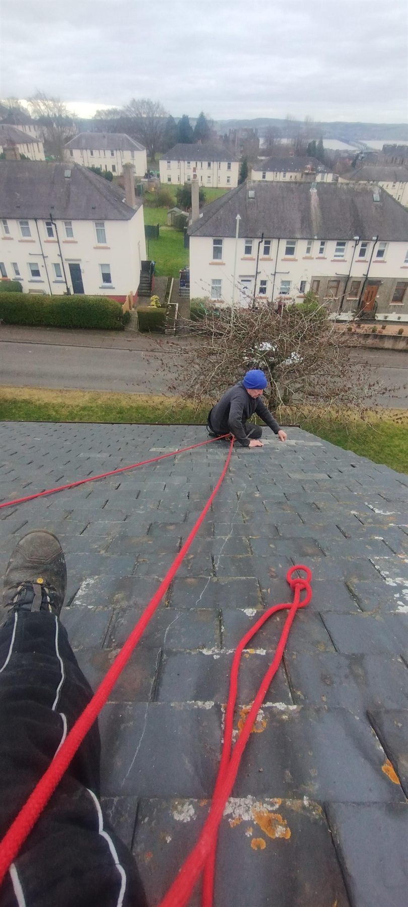 Roped up on a steep pitch — Harness and lines rigged before anything else goes on. Steep Scots slate is no place to be improvising.
