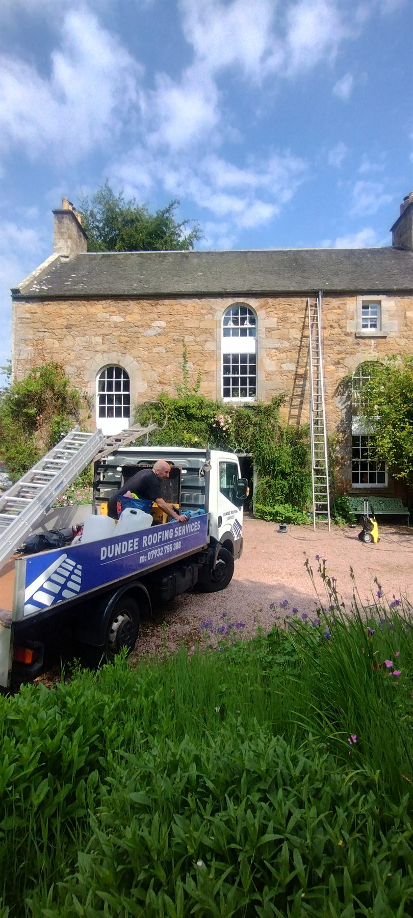 Dundee Roofing Services truck on site with ladders up at a stone-built Tayside house